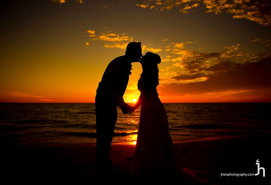 bride and groom kiss at sunset